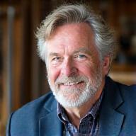 Portrait of John MacLeod, a seasoned master fishing rod craftsman with a warm, experienced expression.